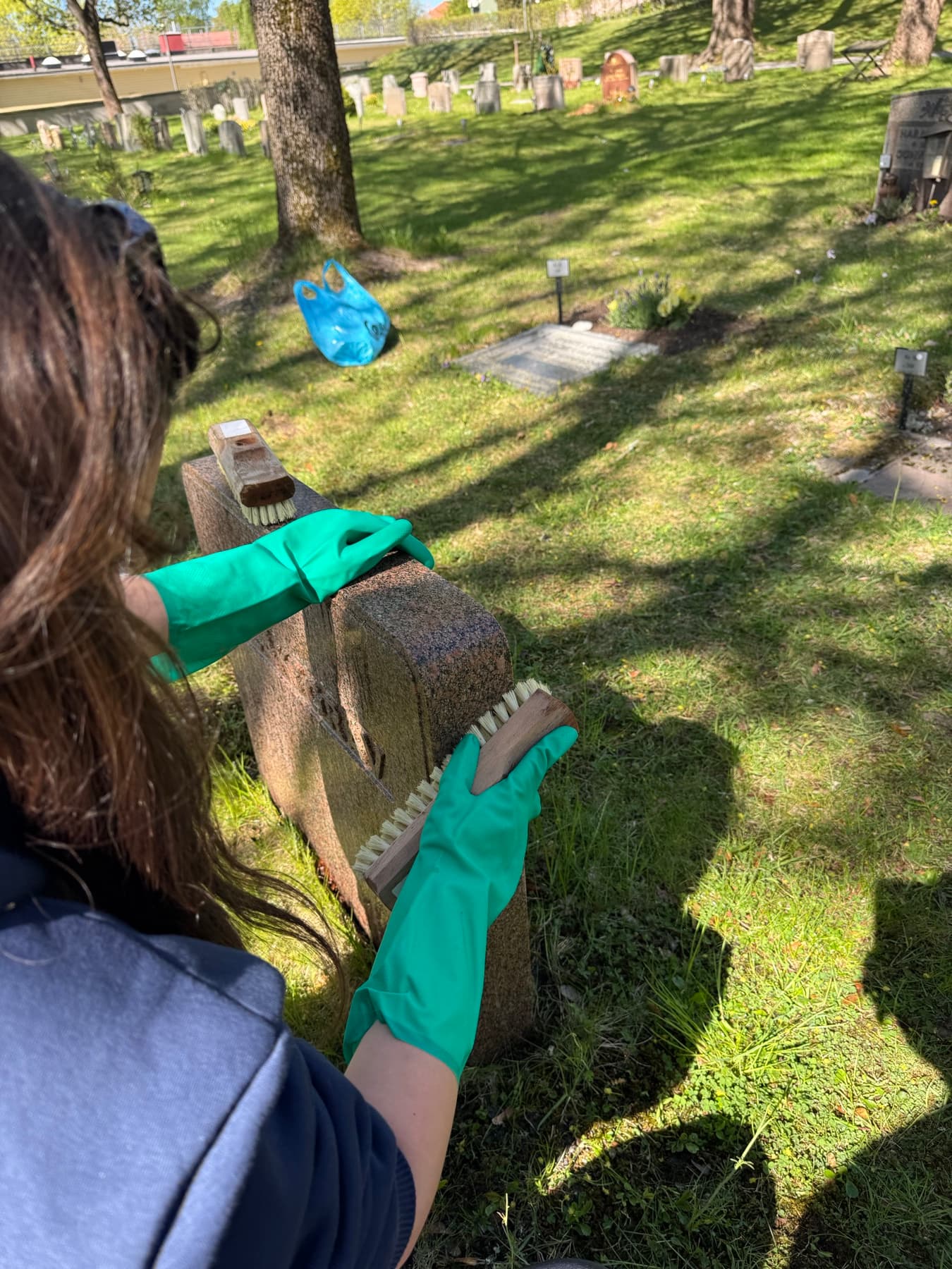 Vår medarbetare tvättar gravsten för hand med skurborste