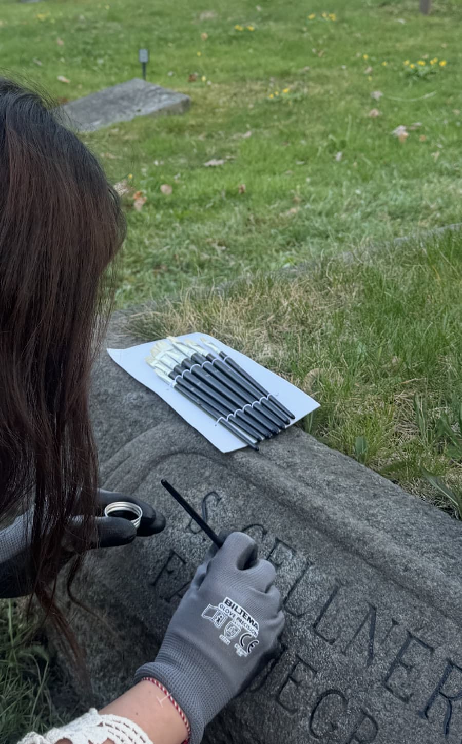 Vår medarbetare fyller i bokstäver på en gravsten